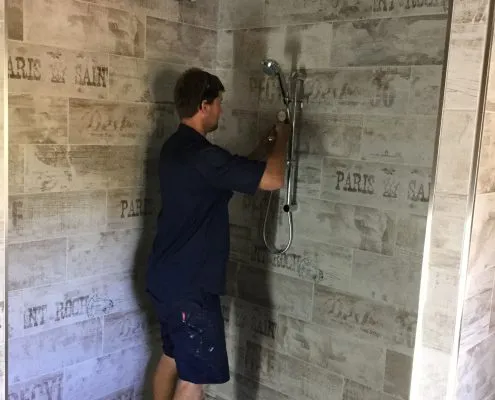 Plumber installing shower rail in Gladstone