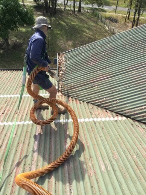 Plumber on roof clearing blocked gutters - Gutter Cleaning Gladstone, QLD