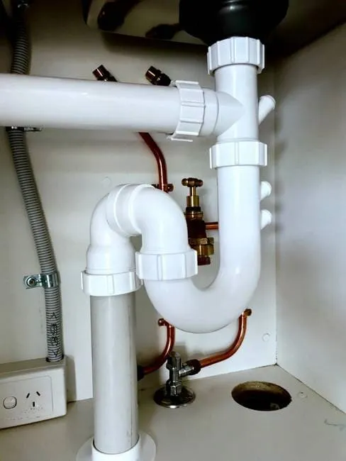 PVC trap and copper piping under kitchen sink