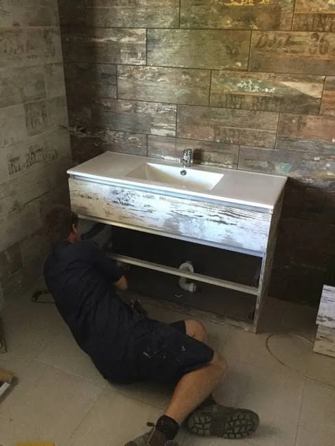 Plumber connecting vanity plumbing in Gladstone